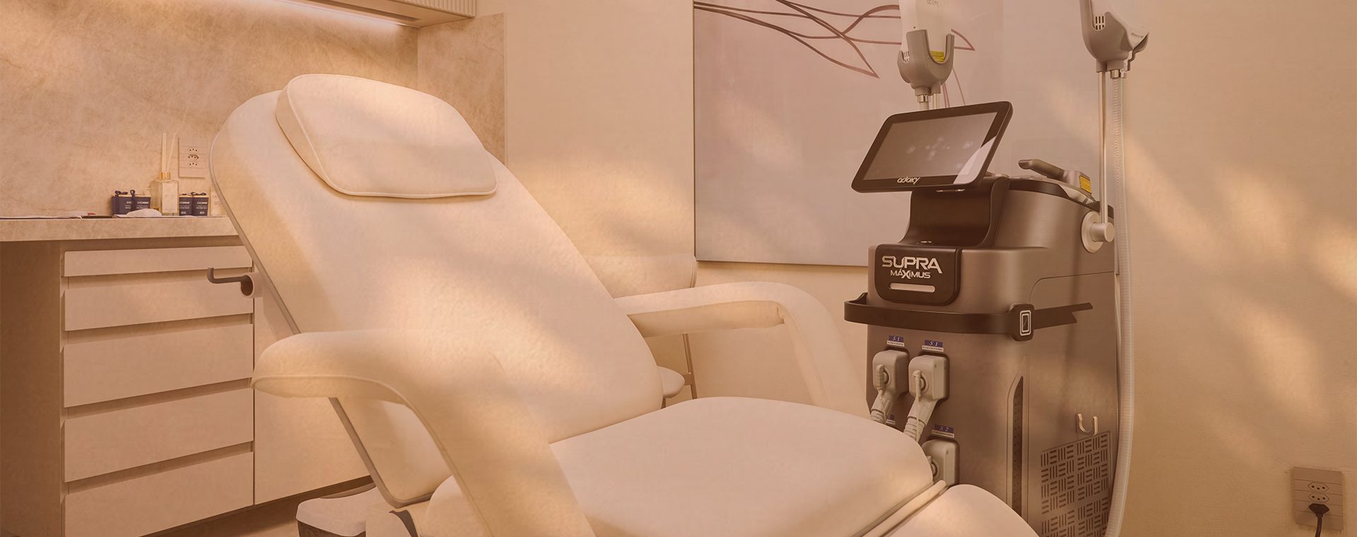 Sala de procedimentos da Clínica Elos com maca e equipamento SUPRA Máximus, em tom sépia